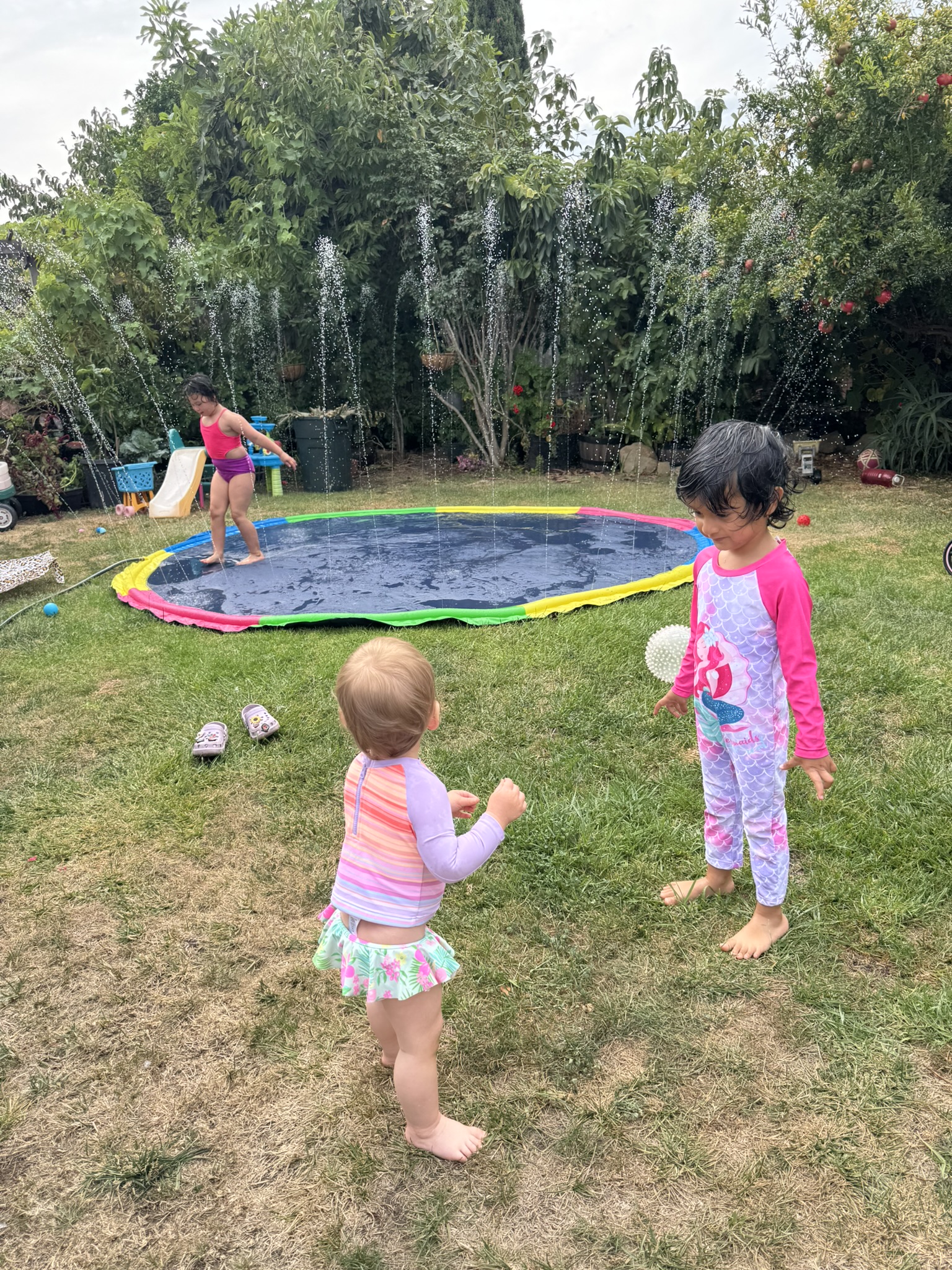 Children playing joyfully outdoors in the backyard garden at Patty's Loving Care